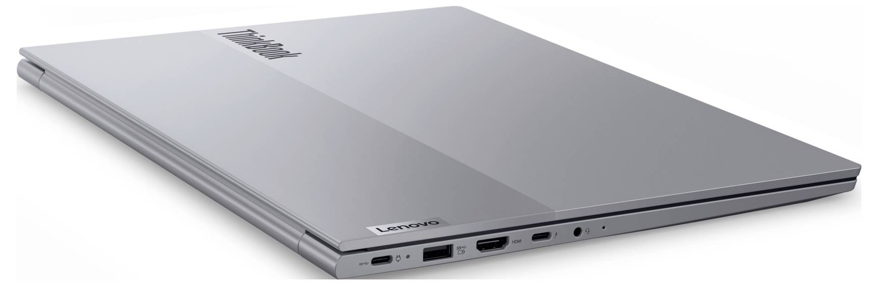 Ein geschlossener silberner Lenovo-Laptop mit verschiedenen Anschlüssen an der Seite, darunter USB und HDMI, von oben und leicht schräg betrachtet.