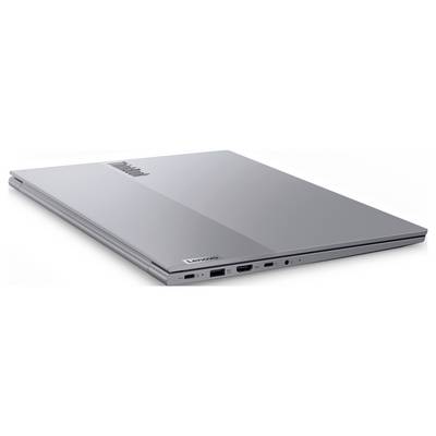 Ein geschlossener silberner Lenovo-Laptop mit verschiedenen Anschlüssen an der Seite, darunter USB und HDMI, von oben und leicht schräg betrachtet.
