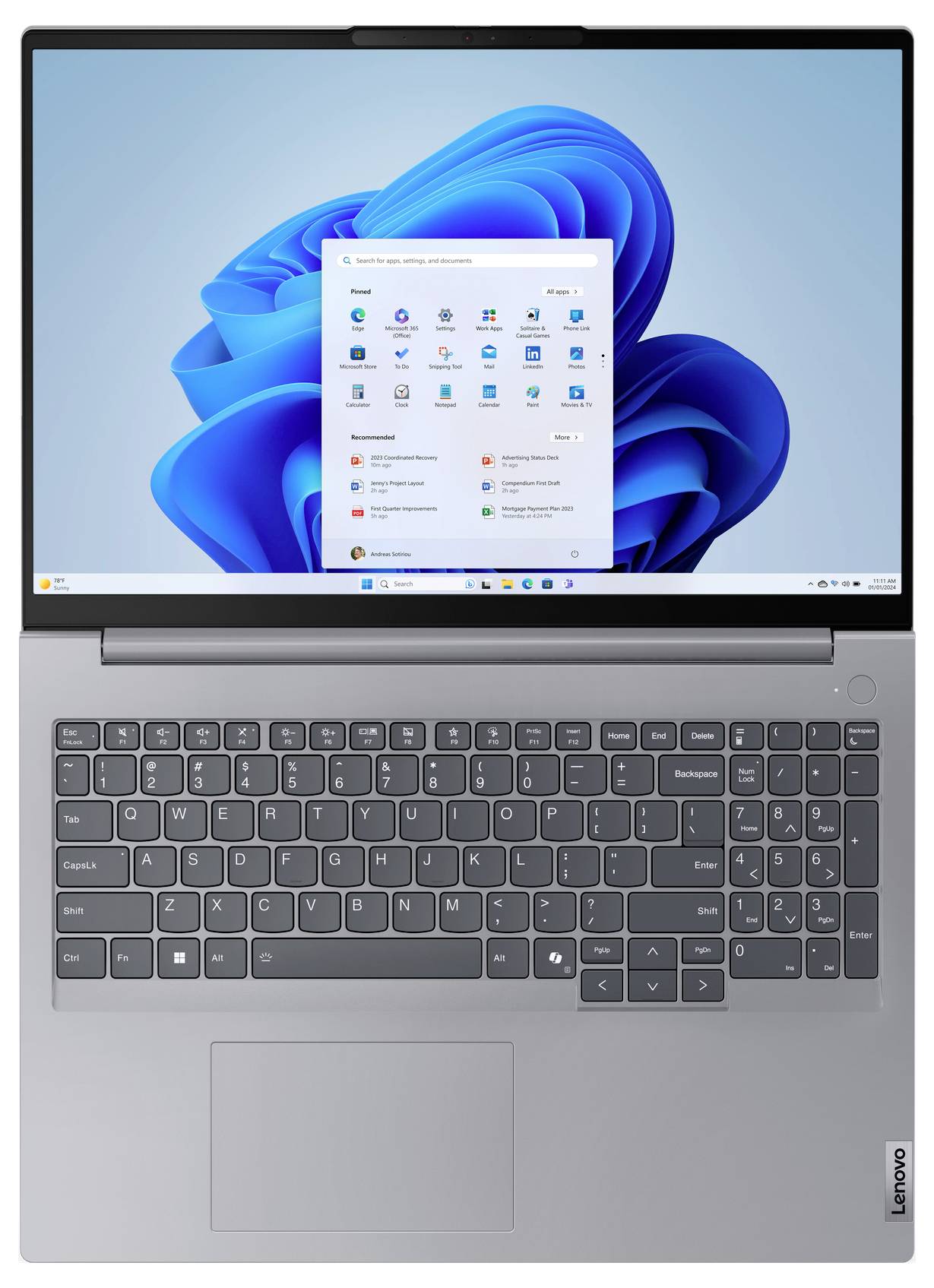Ein grauer Laptop mit einer Tastatur in voller Größe und einem Touchpad, auf dem der Windows 11 Startbildschirm mit mehreren Anwendungssymbolen angezeigt wird.