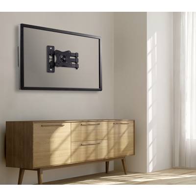 Eine an der Wand befestigte Fernseher mit abgenommenem Bildschirm, wodurch die Halterung sichtbar wird, hängt über einem Holzsideboard in einem sonnendurchfluteten Raum.