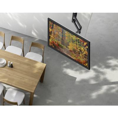 Ein an der Wand montierter Fernseher, der eine farbenprächtige Herbstwaldszene zeigt, ist neben einem Esstisch mit sechs Stühlen in einem modernen Raum platziert.