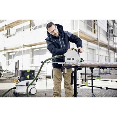 Mann, der eine Festool-Säge im Freien auf einer Baustelle verwendet und Schutzausrüstung trägt. Gerüst und Gebäudefassade im Hintergrund.
