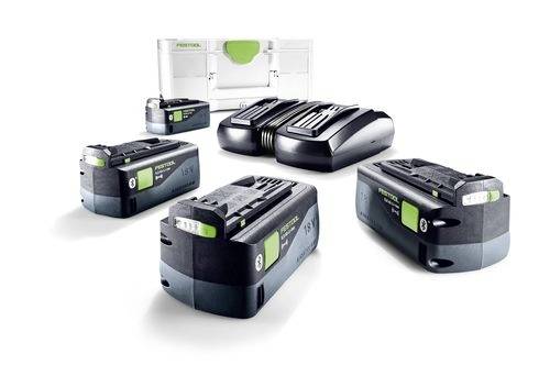 Vier Festool-Akkus und ein Doppelladegerät auf weißem Hintergrund. Eine weiße Werkzeugbox ist dahinter platziert.
