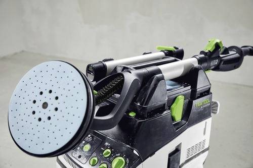 Eine Poliermaschine mit einer kreisförmigen Schleifscheibe, die an der Seite mit Tasten und Einstellungsrädern versehen ist, wird im Innenraum präsentiert.