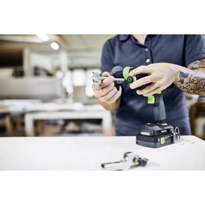 Eine Person verwendet einen kabellosen Akkuschrauber, um eine Befestigung in einer Werkstatt anzubringen und damit eine Bau- oder Heimwerkeraufgabe zu demonstrieren.