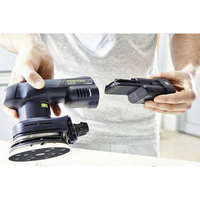 Eine Person hält eine schwarze Akku-Schleifmaschine in einer Hand und den abnehmbaren Akku in der anderen Hand und zeigt, wie man diesen auswechselt.