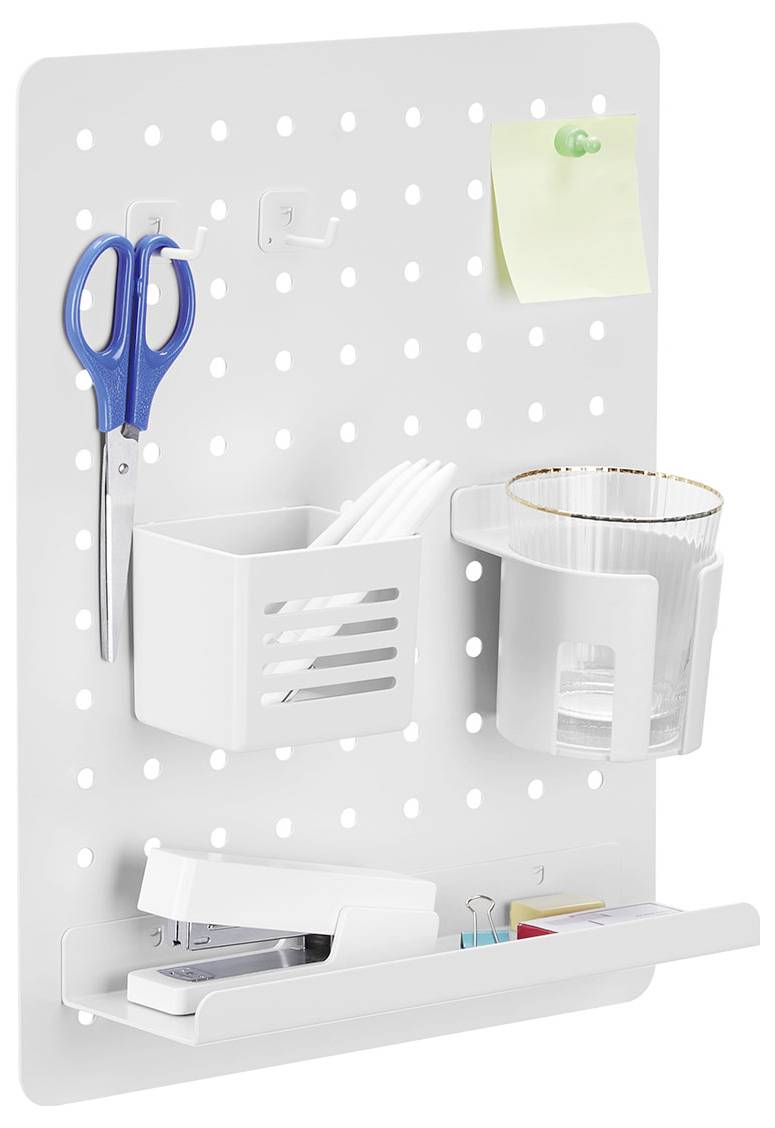Eine weiße Pegboard mit Haken, an denen Scheren hängen, ein kleiner Behälter mit Plastikbesteck und zwei Behältern, einer mit einem Glas und der andere mit einem Hefter.