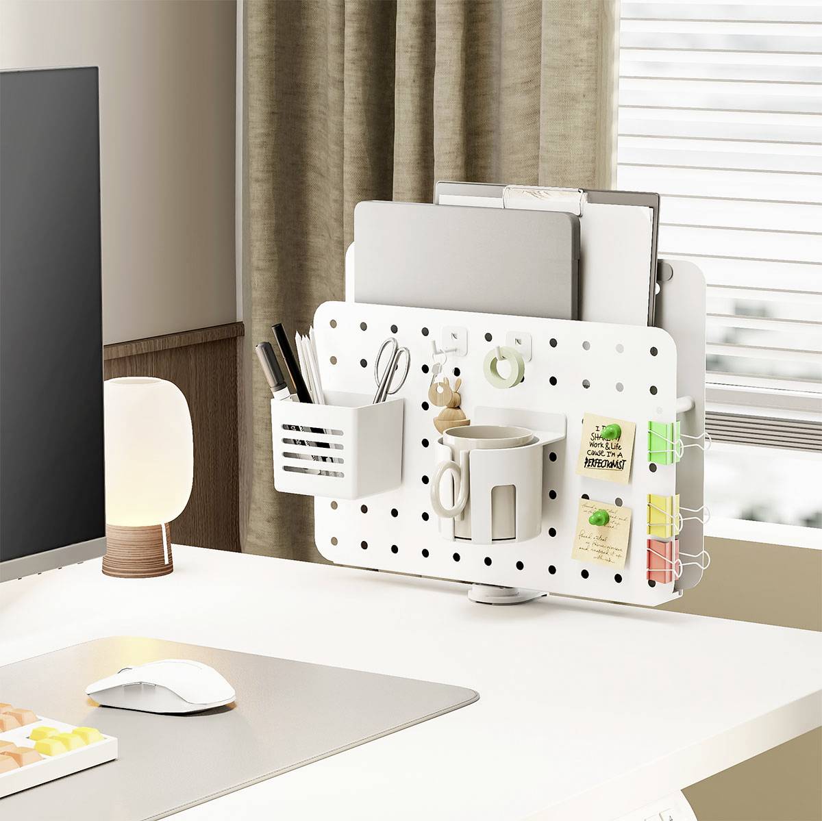 Ein minimalistischer Büroschreibtisch mit einer Lochplattenablage, die einen Stiftehalter, eine Tasse, Notizbücher und dekorative Pflanzen in der Nähe eines Fensters trägt.