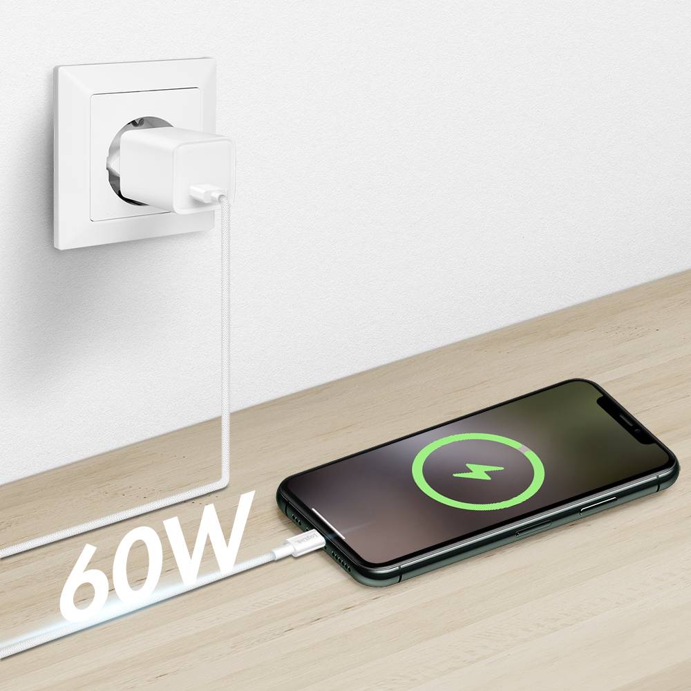Ein Smartphone liegt auf einem Tisch und lädt, mit einem weißen Kabel mit der Aufschrift „60W" an eine Wandsteckdose angeschlossen. Der Bildschirm des Telefons zeigt ein Ladessymbol.