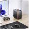 Eine elegante Computereinrichtung mit einem Monitor, der ein blaues geometrisches Wirbeldesign zeigt, einem drahtlosen Gamepad, einer Tastatur und einem kompakten, modernen Desktop-Computer.
