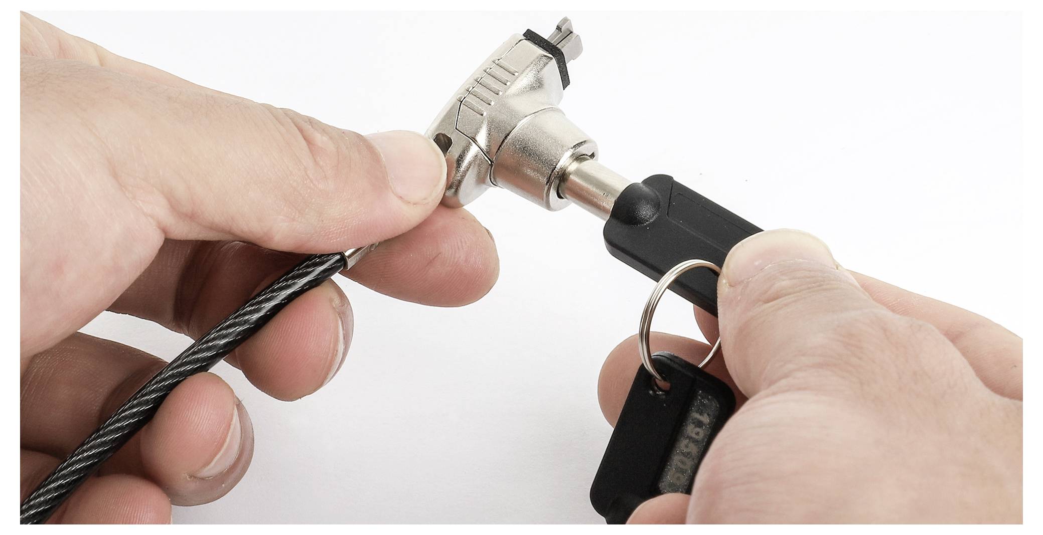 „Hände, die einen Schlüssel in ein Kabelschloss einführen", zeigt eine Sicherheitsvorrichtung, die in Position gebracht wird.