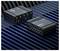 Zwei schwarze Teltonika RUTX54-Router sind auf einer blau-schwarz gestreiften Oberfläche platziert. Jeder Router verfügt über mehrere Anschlüsse und Antennen.