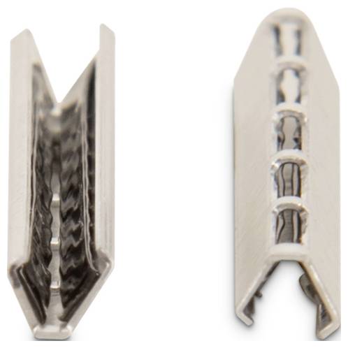 Zwei metallische Stücke, jeweils mit einer V-ähnlichen Form, nebeneinander platziert. Das linke Stück zeigt ein detailliertes Inneres mit winkeligen Mustern, während das rechte eine offenere, gitterartige Struktur aufweist.