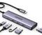Ein Multiport-USB-C-Hub der Marke 'UGREEN' mit mehreren USB-Anschlüssen, einem HDMI-Anschluss und einem microSD-Kartenslot, zusammen mit Verbindungskabeln.