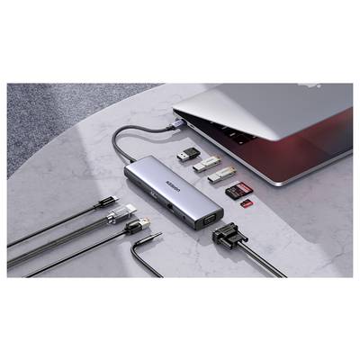 Ein Laptop, der mit einem USB-C-Hub mit mehreren Anschlüssen verbunden ist, darunter HDMI-, USB- und Kartenleser-Steckplätze, der verschiedene Geräte angeschlossen zeigt.