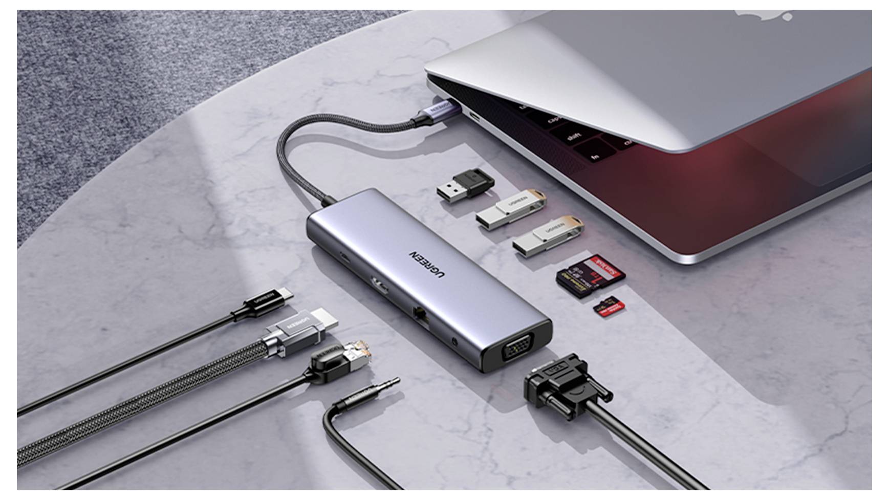 Ein Laptop, der an einen Multiport-Adapter angeschlossen ist, mit verschiedenen USB-Laufwerken und Speicherkarten daneben, was die Konnektivitätsoptionen veranschaulicht.