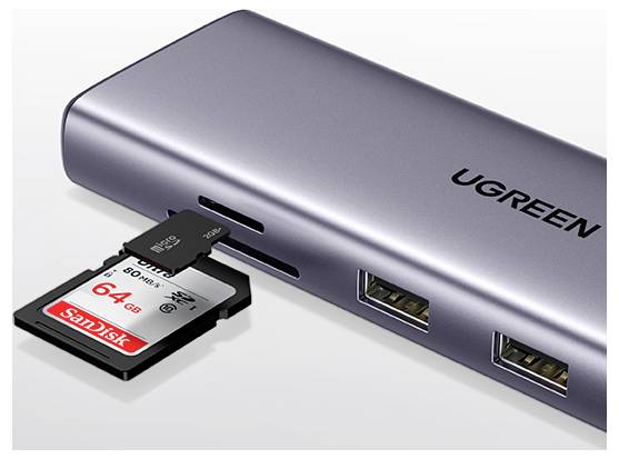 Ein silberner UGREEN USB-Hub mit zwei Anschlüssen und einer SD-Karte, die in seinen Steckplatz eingesetzt ist. Die SD-Karte ist von SanDisk und mit ‚64 GB' gekennzeichnet.