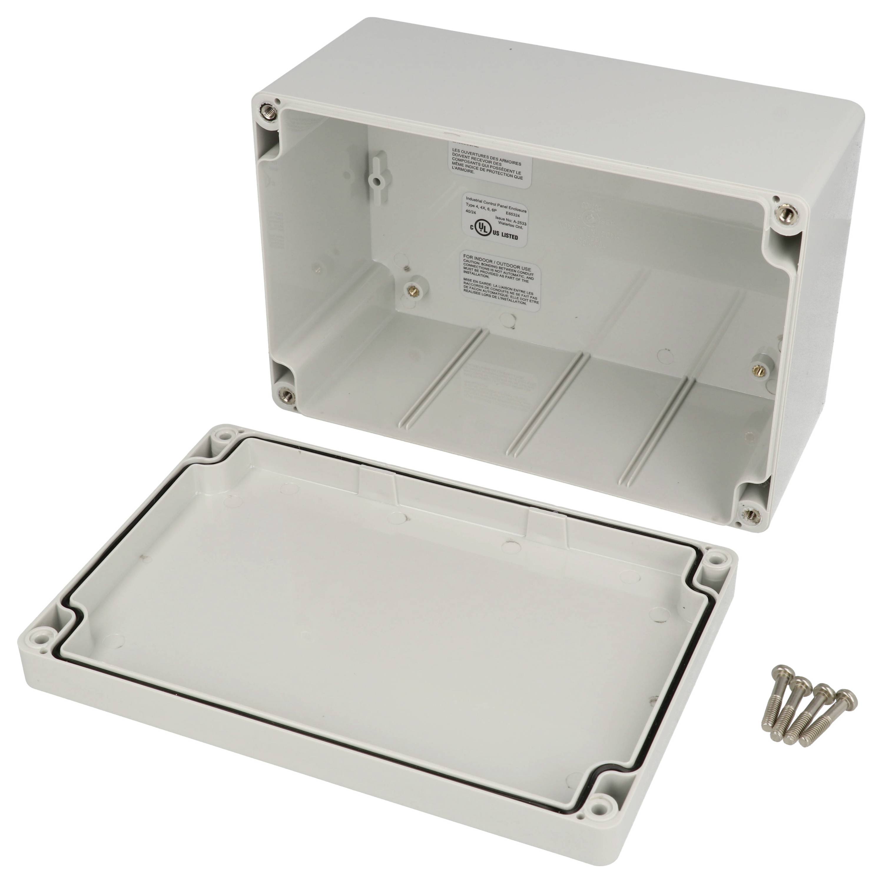 Eine offene rechteckige graue elektrische Gehäuse mit einem abgenommenen Deckel und vier Schrauben daneben, die einen einfachen Innenraum zeigt.