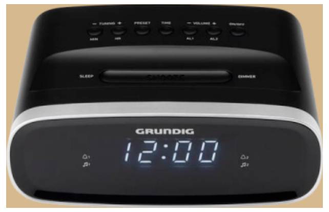 Eine digitale Weckuhr, die '12:00' auf ihrem Display zeigt, mit Bedienungstasten für Abstimmung, Voreinstellung, Lautstärke, Schlummern und Ein/Aus oben auf dem Gerät.