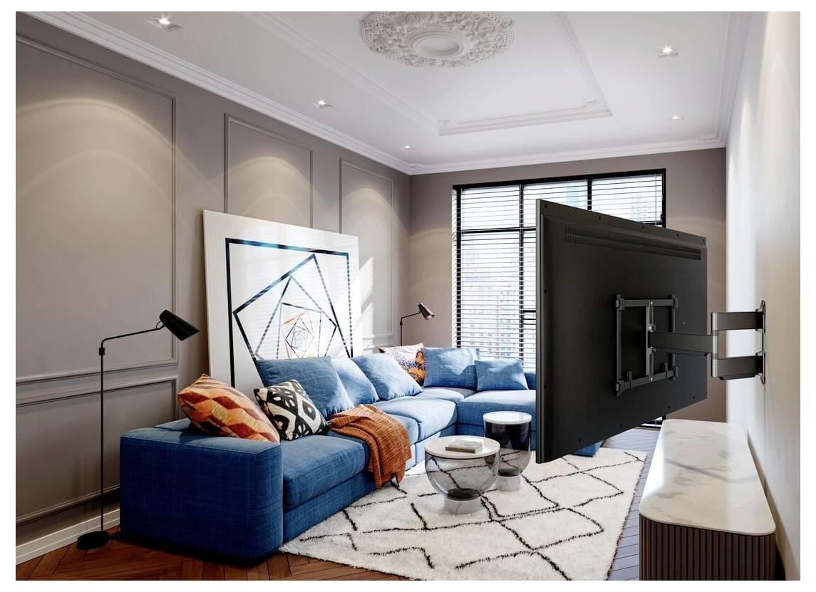 Ein modernes Wohnzimmer mit einem blauen Ecksofa, bunten Kissen, geometrischen Kunstwerken, einer wandmontierten TV und Stehlampen, die eine gemütliche Atmosphäre schaffen.