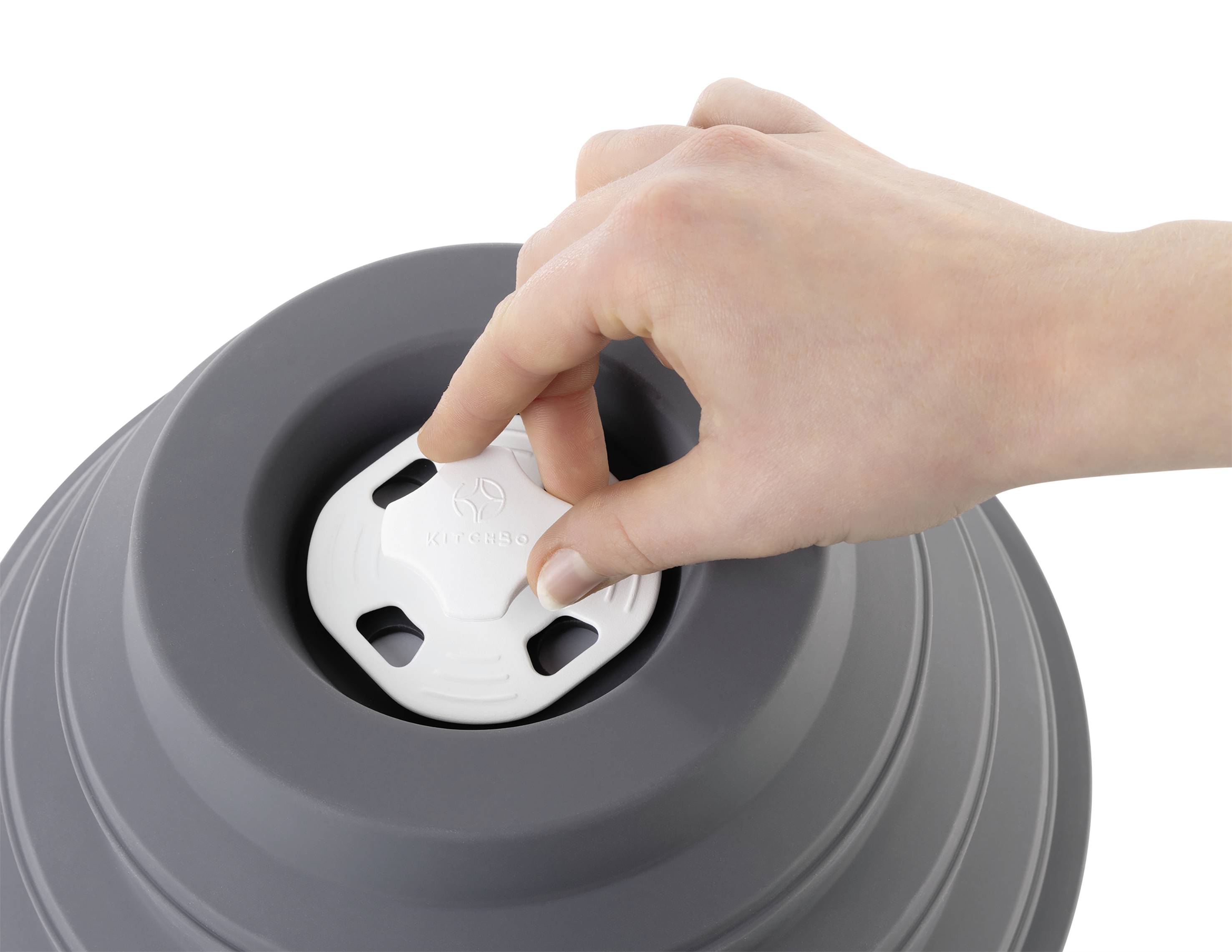 Eine Hand verschließt den Deckel eines grauen, zusammenklappbaren Silikonbehälters und unterstreicht damit dessen Lagerfunktion.