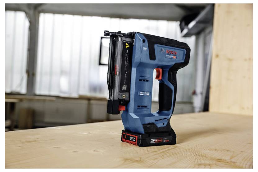Eine Bosch-Nagelmaschine befindet sich auf einer Holzoberfläche in einer Werkstattumgebung und betont ihr kompaktes Design und die kabellose Funktionalität.