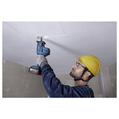 Ein Bauarbeiter mit gelbem Schutzhelm und Sicherheitsbrille verwendet einen kabellosen Akkuschrauber, um eine Deckenplatte in einem Raum zu installieren.