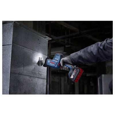 Eine Person trägt einen Handschuh und verwendet ein Elektrowerkzeug, um in einer industriellen Umgebung Metall zu schneiden.