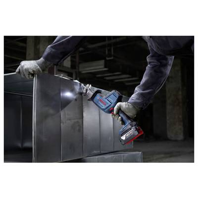 Eine Person mit Handschuhen benutzt ein Elektrowerkzeug, um Metallbleche in einem industriellen Umfeld zu schneiden und damit die Nutzung des Geräts zu demonstrieren.
