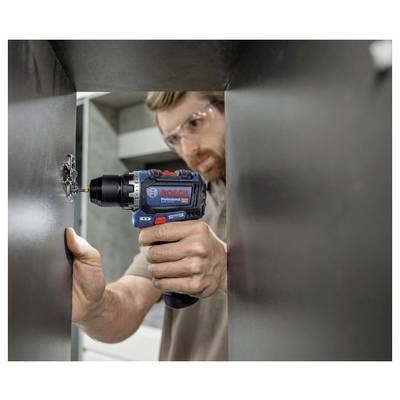 Eine Person, die einen Bosch-Bohrer verwendet, um ein Loch in ein Metallblech zu bohren, trägt Sicherheitsbrille. Der Fokus liegt auf sicherer Handhabung und Werkzeugeffizienz.