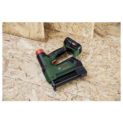 Eine Bosch Akku-Nagelmaschine auf einem Sperrholzboden, vor einer Holzvertäfelung.