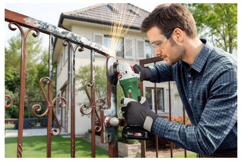 Eine Person mit Sicherheitsbrille und Handschuhen verwendet eine Winkelschleifer, um Rost von einem Metalltor in einem Wohngebiet zu entfernen.