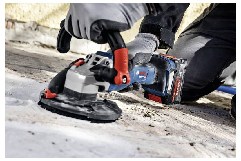 Eine Person, die ein Elektrowerkzeug verwendet, um eine Oberfläche zu schleifen und dabei Schutzhandschuhe trägt. Das Werkzeug wird fest gehalten und glättet eine Beton- oder Steinoberfläche.