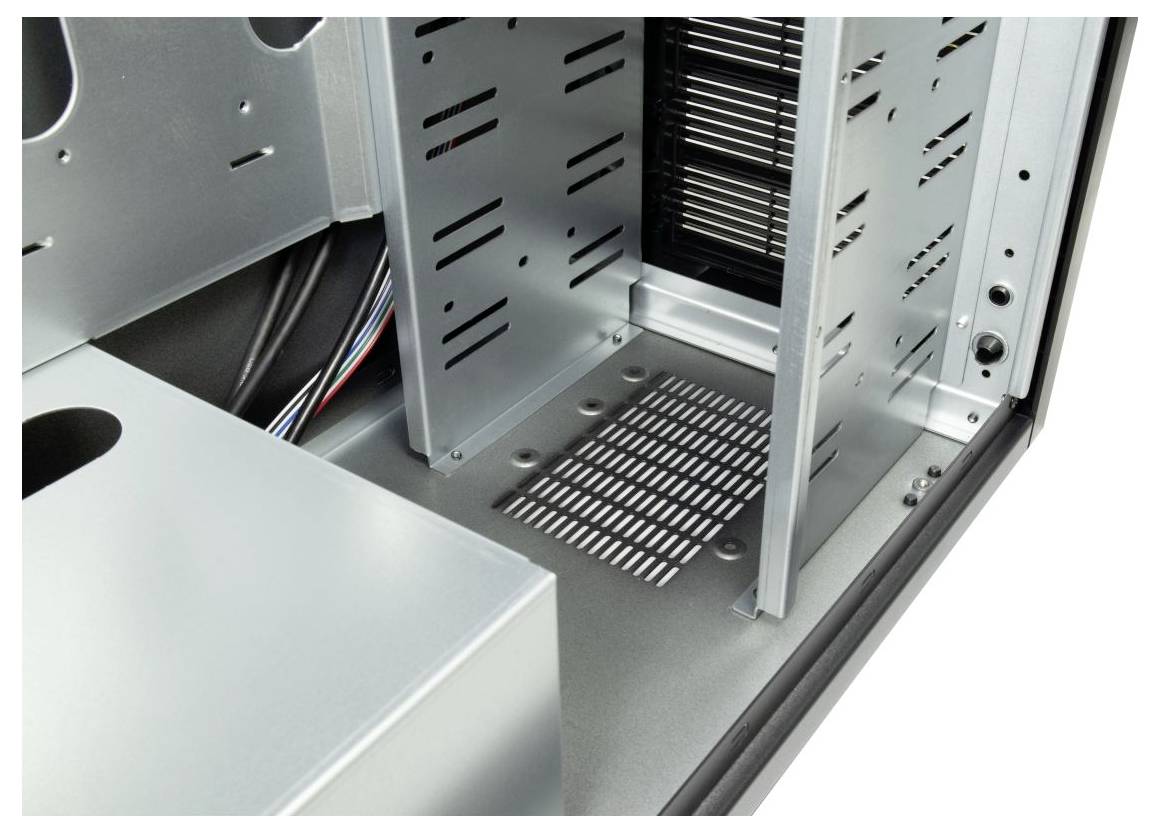 Das Innenleben eines Computergehäuses mit mehreren leeren Laufwerkschächten und Kabelmanagement-Bereichen, die den verfügbaren Platz für Hardwareinstallation veranschaulichen.