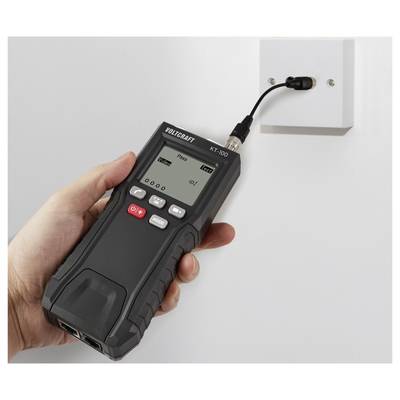 Eine Person hält ein digitales Gerät mit der Anzeige "Pass", das mit einer wandmontierten Steckdose verbunden ist und den elektrischen Strom oder die Spannung testet.