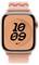 Eine Smartwatch, die die Uhrzeit '10:09' auf einem orangefarbenen geometrischen Hintergrund anzeigt, mit einem rosa gewebten Armband und einem Nike-Logo unten.