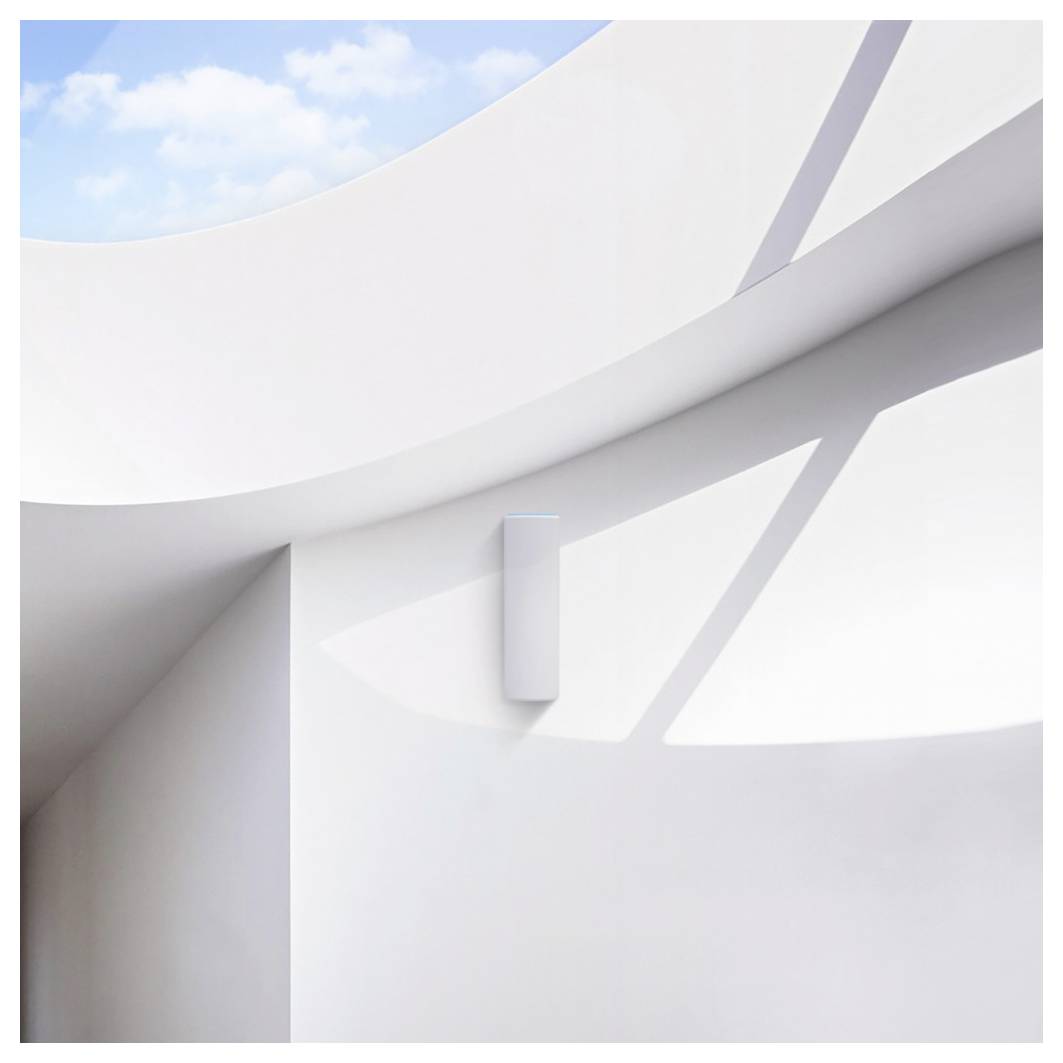 Ein modernes Interieur mit minimalistischem Design, das eine weiße geschwungene Wand und ein rechteckiges weißes Gerät zeigt. Sonnenlicht wirft Schatten und schafft eine ruhige Atmosphäre.