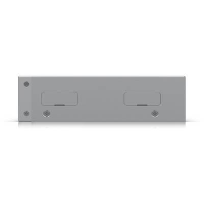 Ein grauer rechteckiger elektronischer Apparat mit zwei kleinen, rechteckigen Vertiefungen oder Schlitzen und vier kreisförmigen schraubenähnlichen Befestigungen.