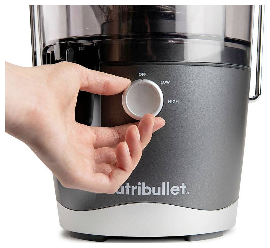 Eine Hand dreht den Regler des Nutribullet-Mixers von "AUS" in Richtung "NIEDRIG". Die Gerätebasis ist dunkelgrau mit dem Nutribullet-Logo.