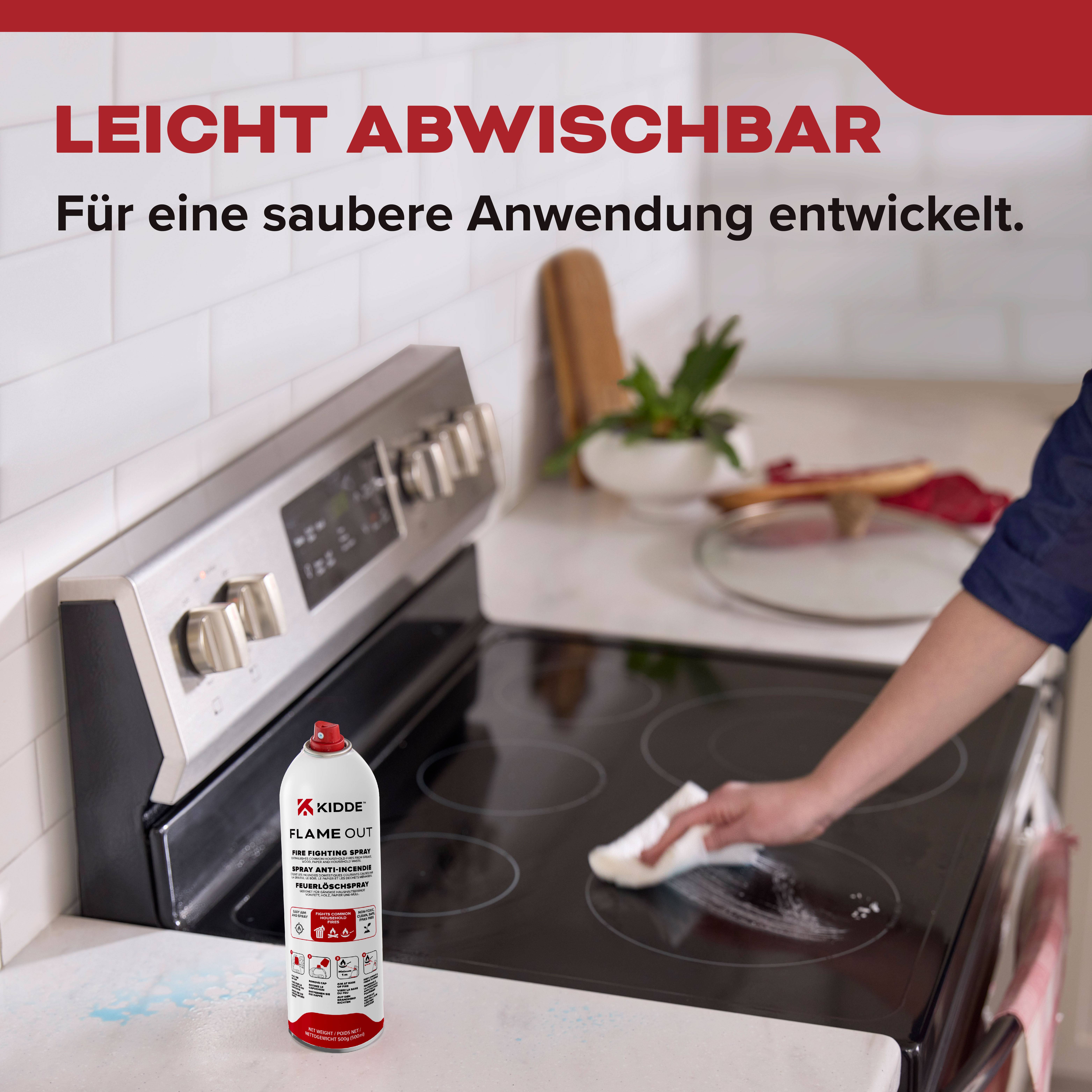 Eine Hand wischt mit einem Tuch eine Herdplatte neben einer Dose von 'Kidde Flame Out' ab, was möglicherweise die Reinigungseinfachheit veranschaulicht. Deutscher Text lautet: 'Leicht abwischbar. Für eine saubere Anwendung entwickelt.'