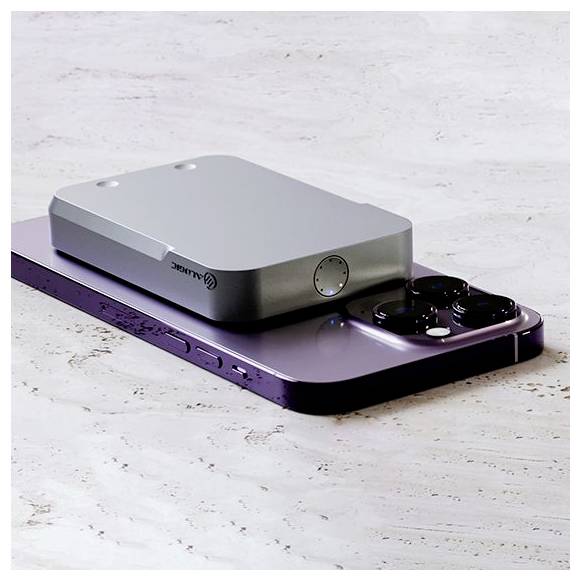 Eine elegante magnetische Powerbank ist auf der Rückseite eines modernen Smartphones befestigt, mit einer Marmoroberfläche darunter. Die Geräte sind miteinander verbunden.
