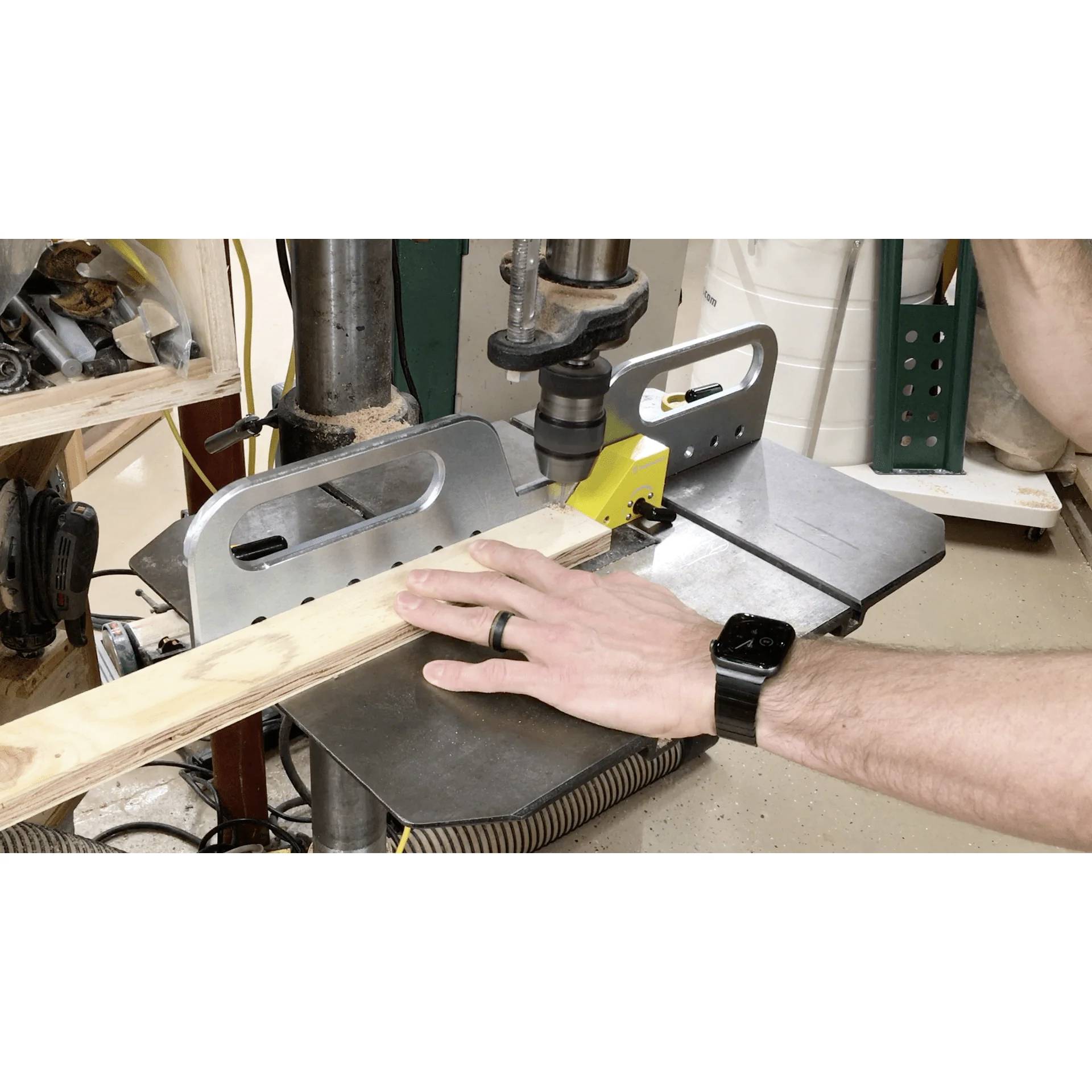 Eine Person verwendet eine Bohrmaschine, um ein Loch in ein Holzbrett in einer Werkstatt zu bohren und damit eine Holzbearbeitungsaktivität zu demonstrieren.