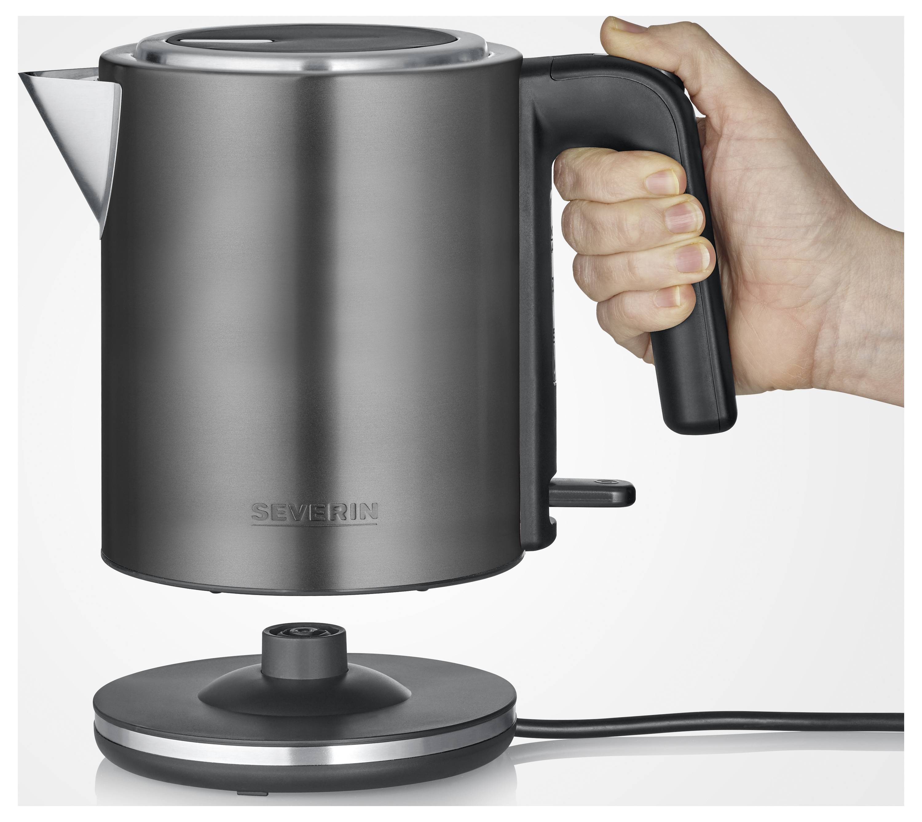 Eine Hand hält einen schwarzen elektrischen Wasserkocher über seiner Basis, bereit, ihn abzustellen. Der Wasserkocher verfügt über ein schlankes Design und eine markante Ausgussöffnung.