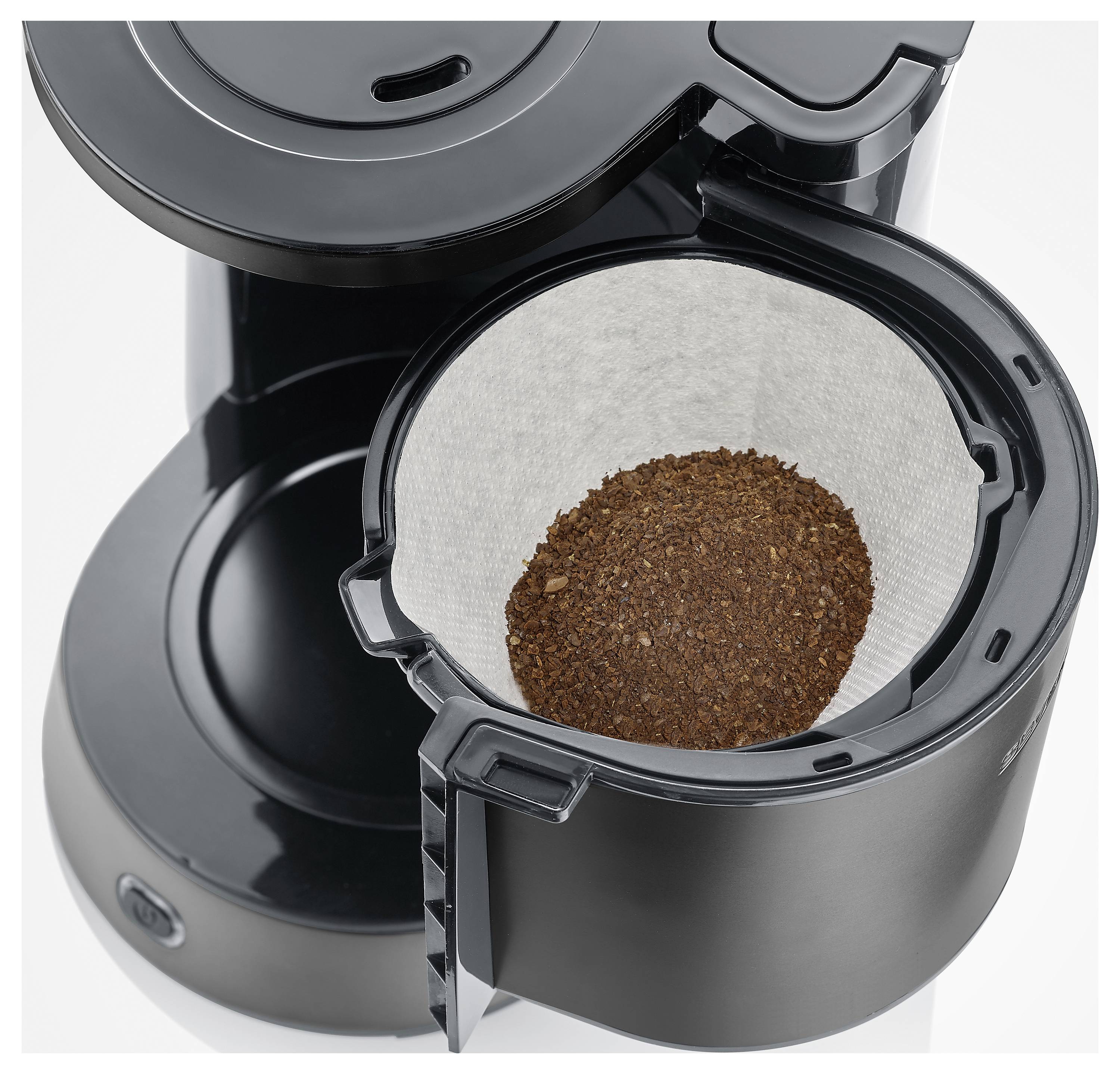Eine schwarze Kaffeemaschine mit offener Abdeckung, die einen Filter mit gemahlenem Kaffee zeigt.