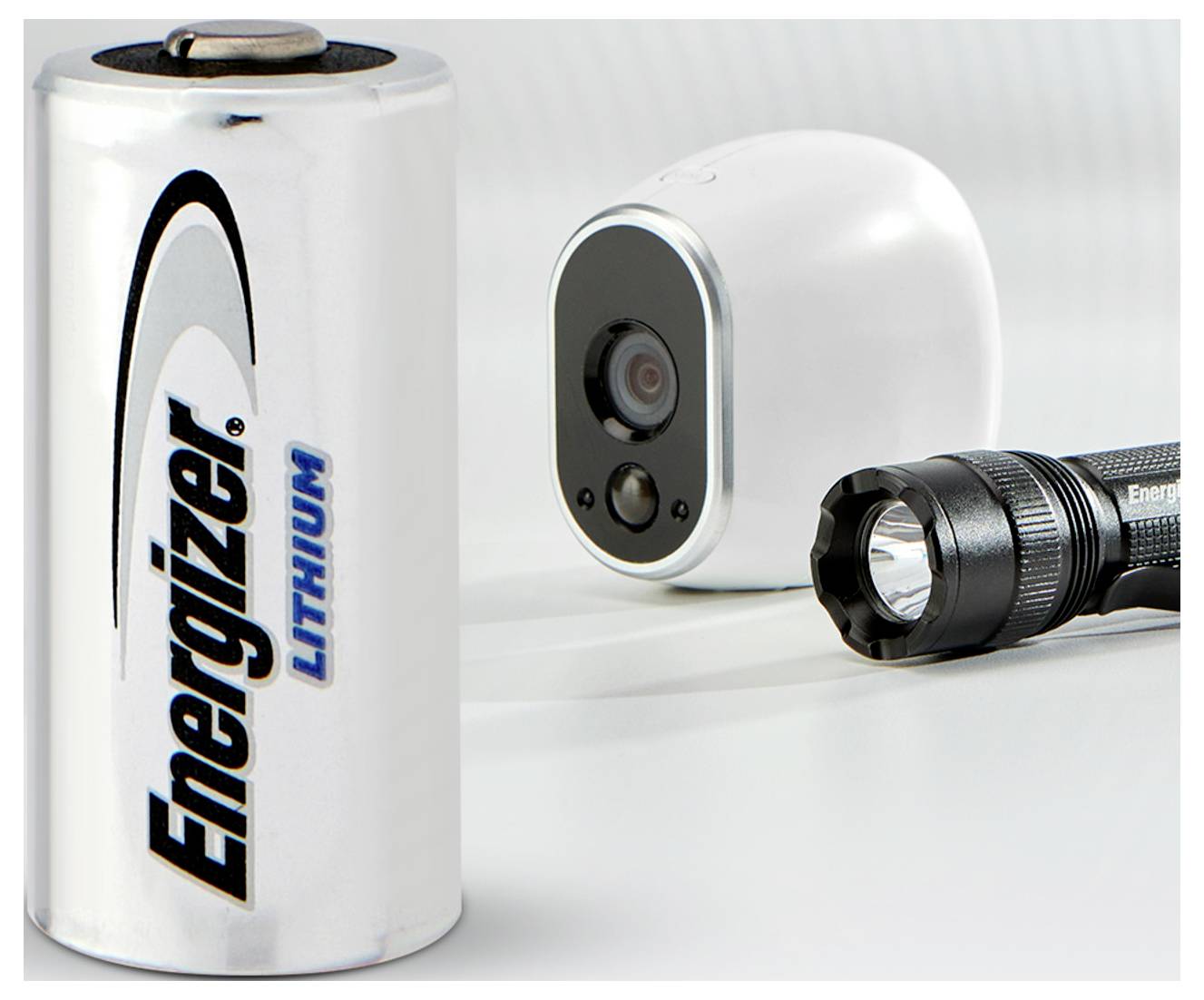 Batterie neben einer Kamera und einer Taschenlampe. Symbolisiert die Energiequelle für elektronische Geräte.