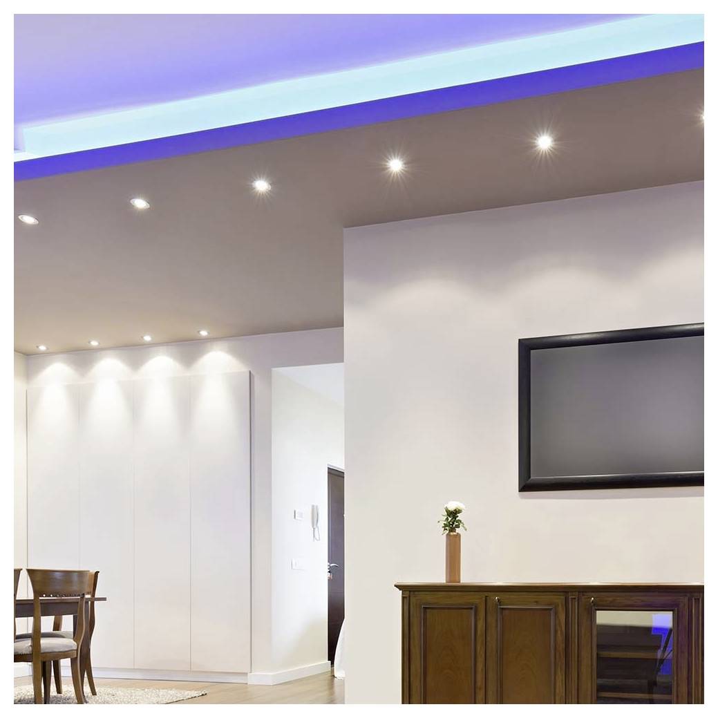 Moderner Wohnraum mit Holzmöbeln, wandmontiertem Fernseher und eingelassenen Deckenleuchten. Minimalistisches Design mit einer kleinen Pflanze auf einem Schrank.