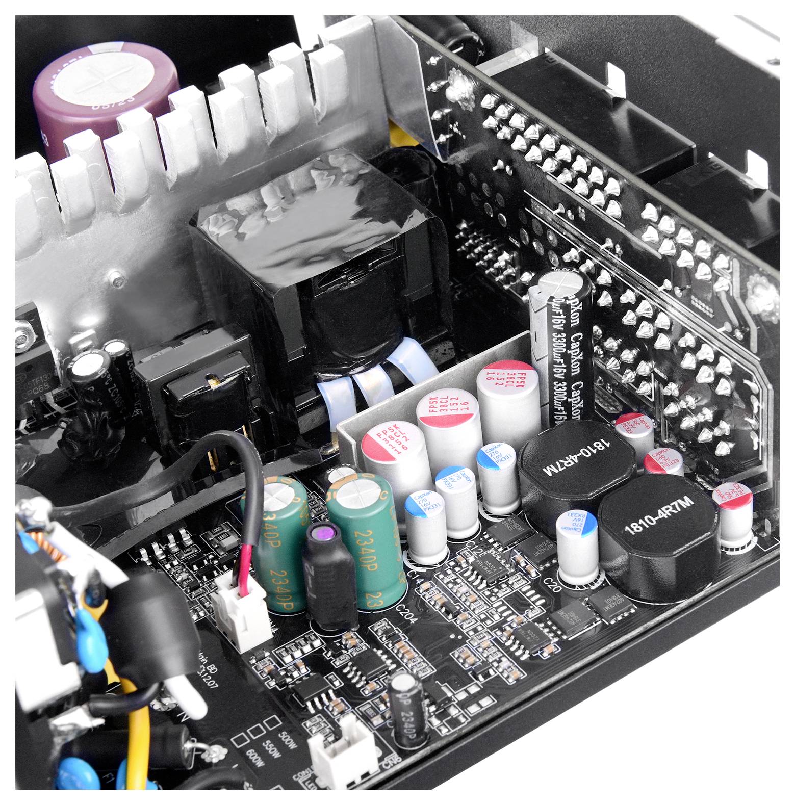 Nahaufnahme einer elektronischen Leiterplatte mit Kondensatoren, Widerständen und Kühlkörpern, die die Komplexität moderner Elektronik veranschaulicht.