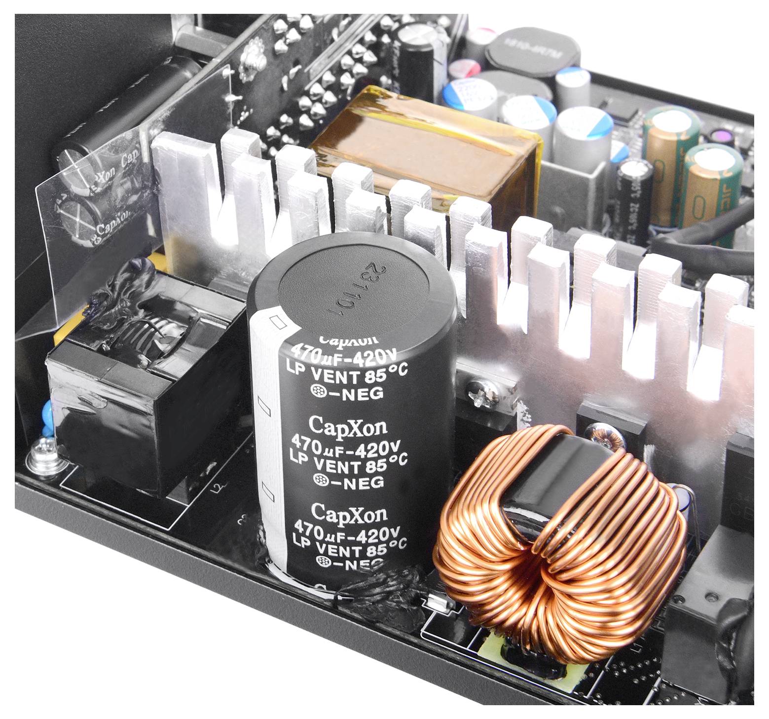 Innere Ansicht eines Netzteilgehäuses mit Kondensatoren, Kühlkörpern und einer Kupferspule, die die elektronischen Komponenten des Geräts hervorhebt.