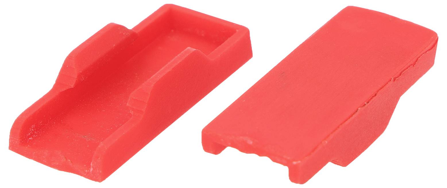 Zwei rote Kunststoffabdeckungen, eine geöffnet und eine innere Nut aufzeigend, die andere geschlossen, möglicherweise zum Schutz von Anschlüssen verwendet.