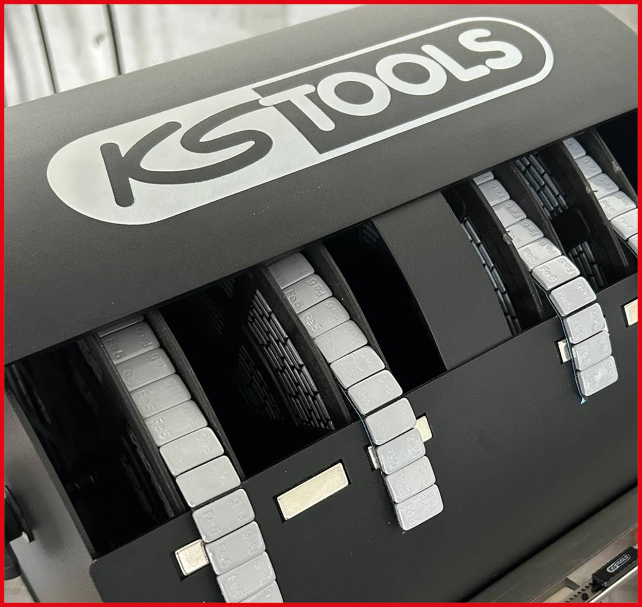 Eine schwarze KS Tools Lochkartenmaschine mit mehreren sichtbaren weißen Karten.